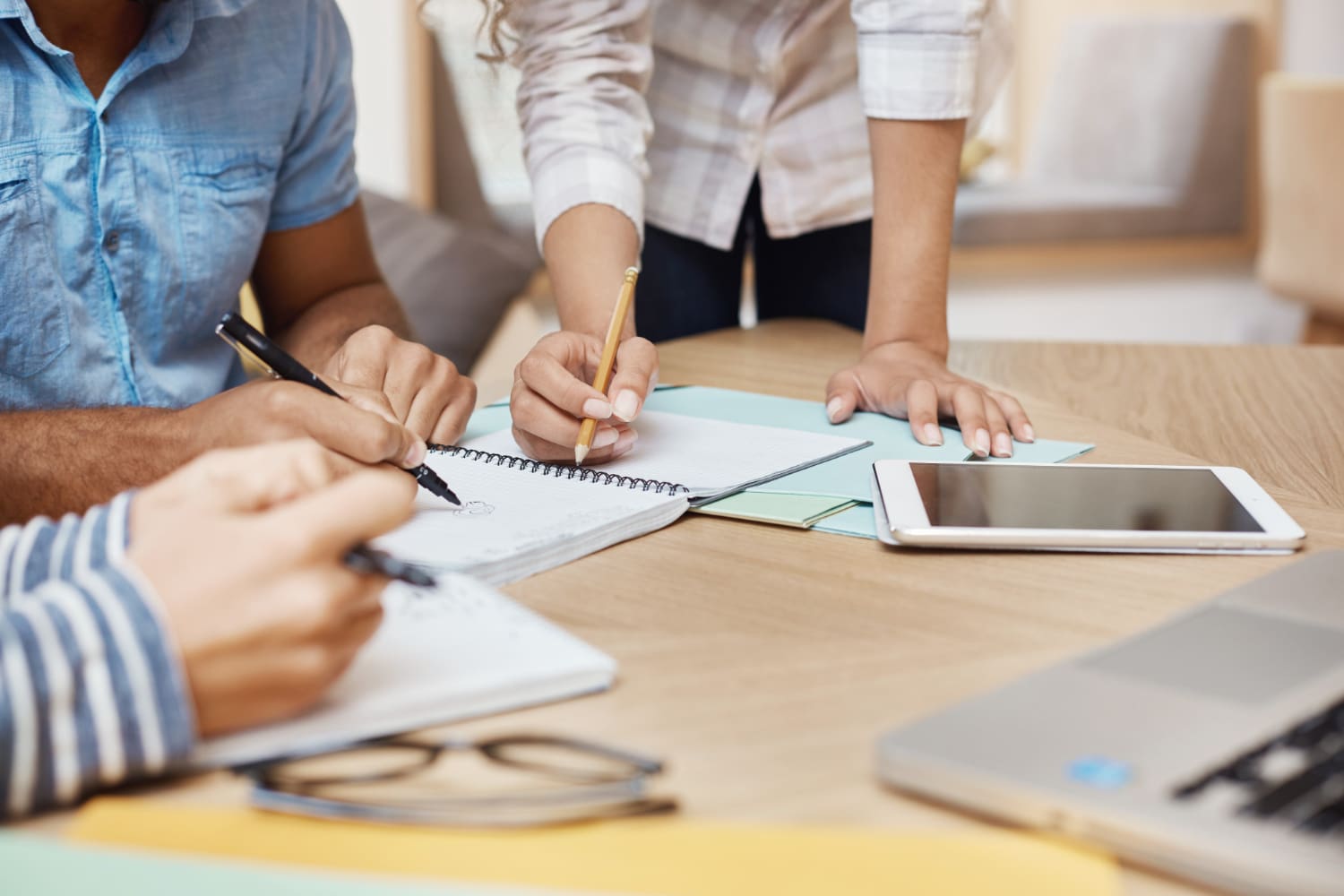 Multiple people writing on paper