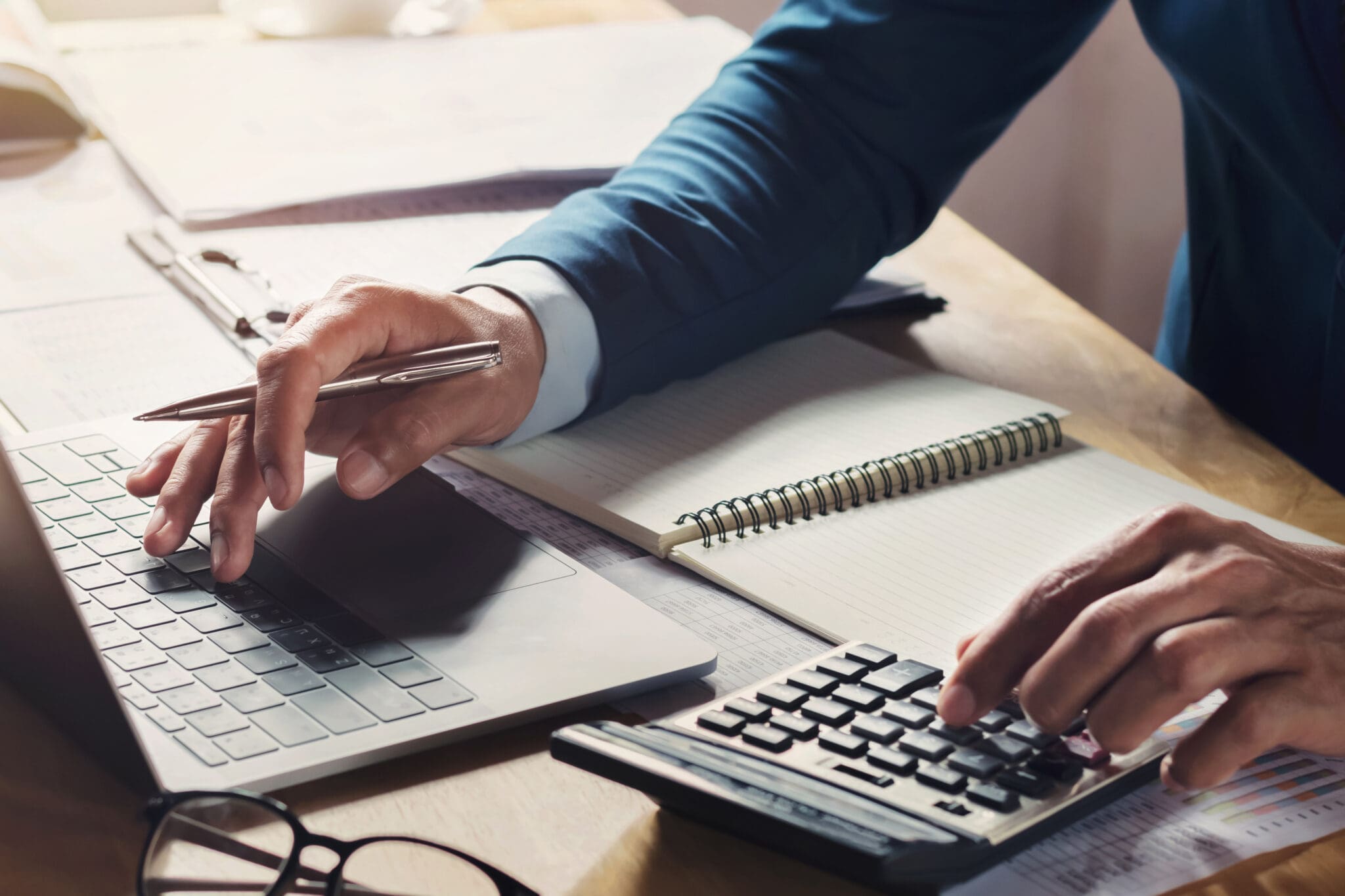 businessman working on calculator and laptop on desk