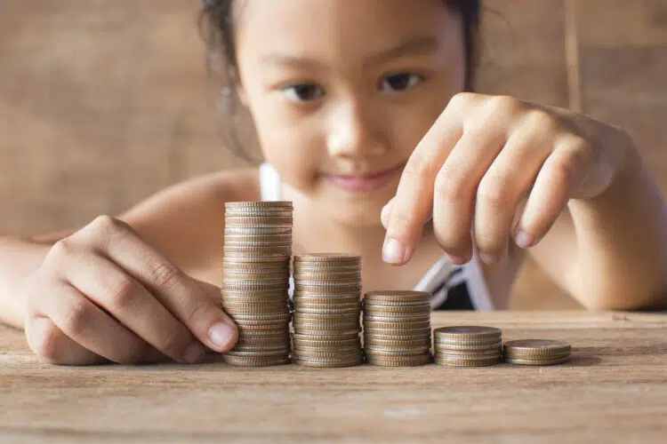 a child counting a pile of coins