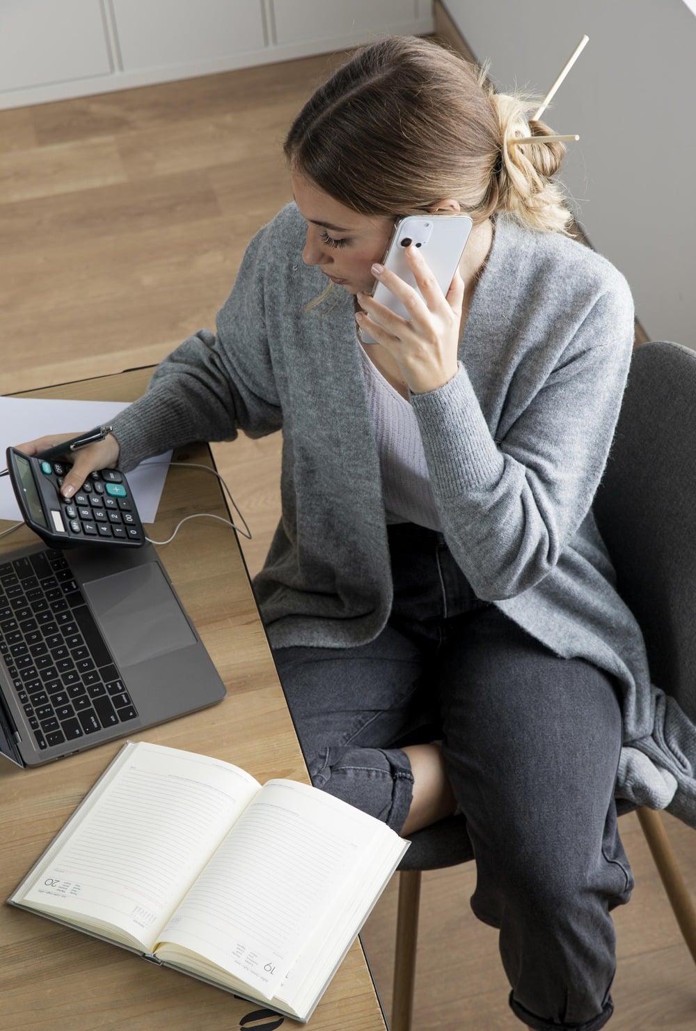 a woman sat at a desk taking a phone call