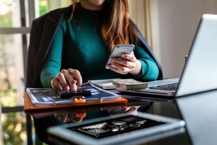 A woman working on tax documents at her desk