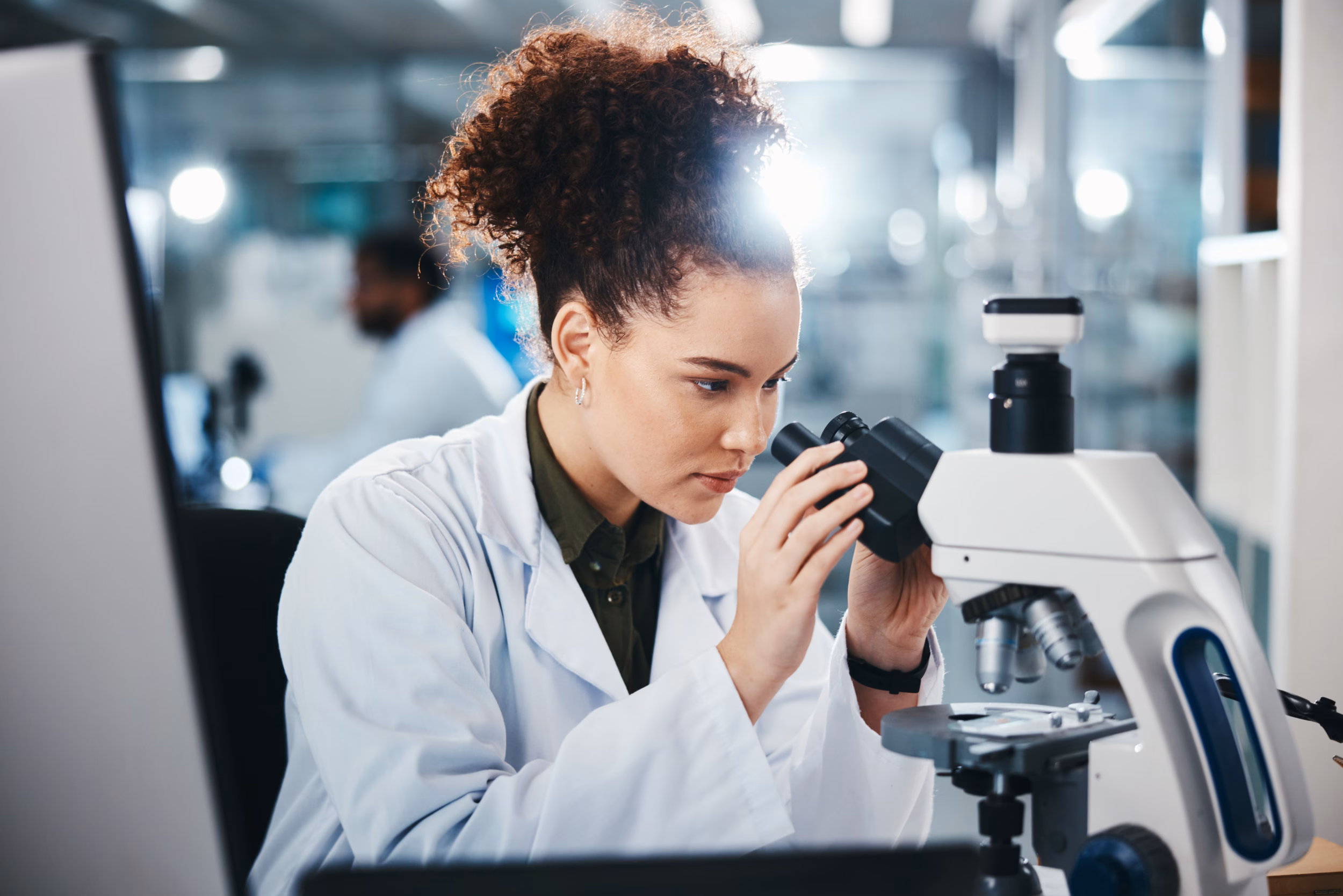 Scientist In A Laboratory Looking Through A Microscope