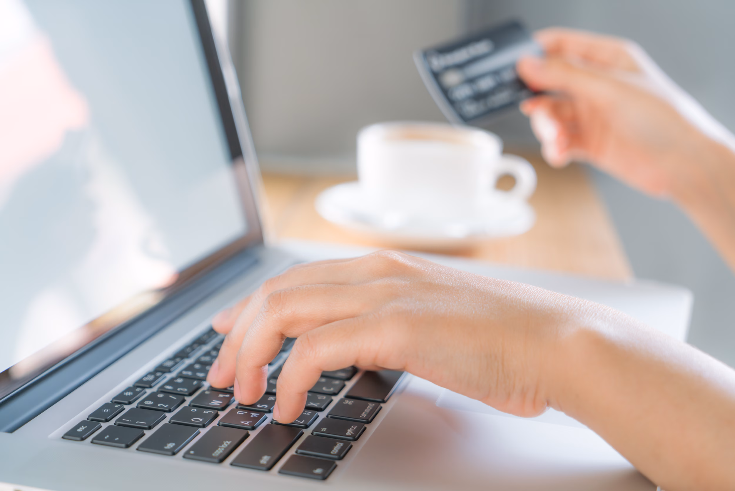 Hands holding a credit card and using laptop computer for online shopping