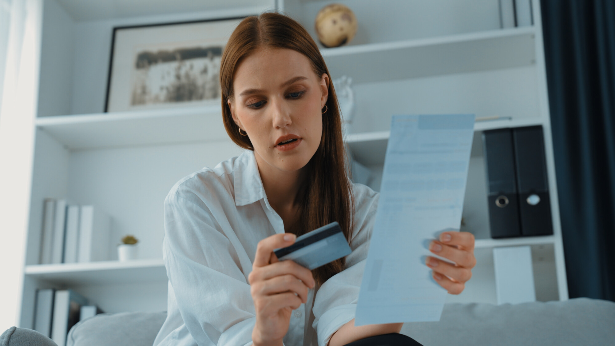 Taxpayer reviewing an HMRC debt notice with bank card in hand