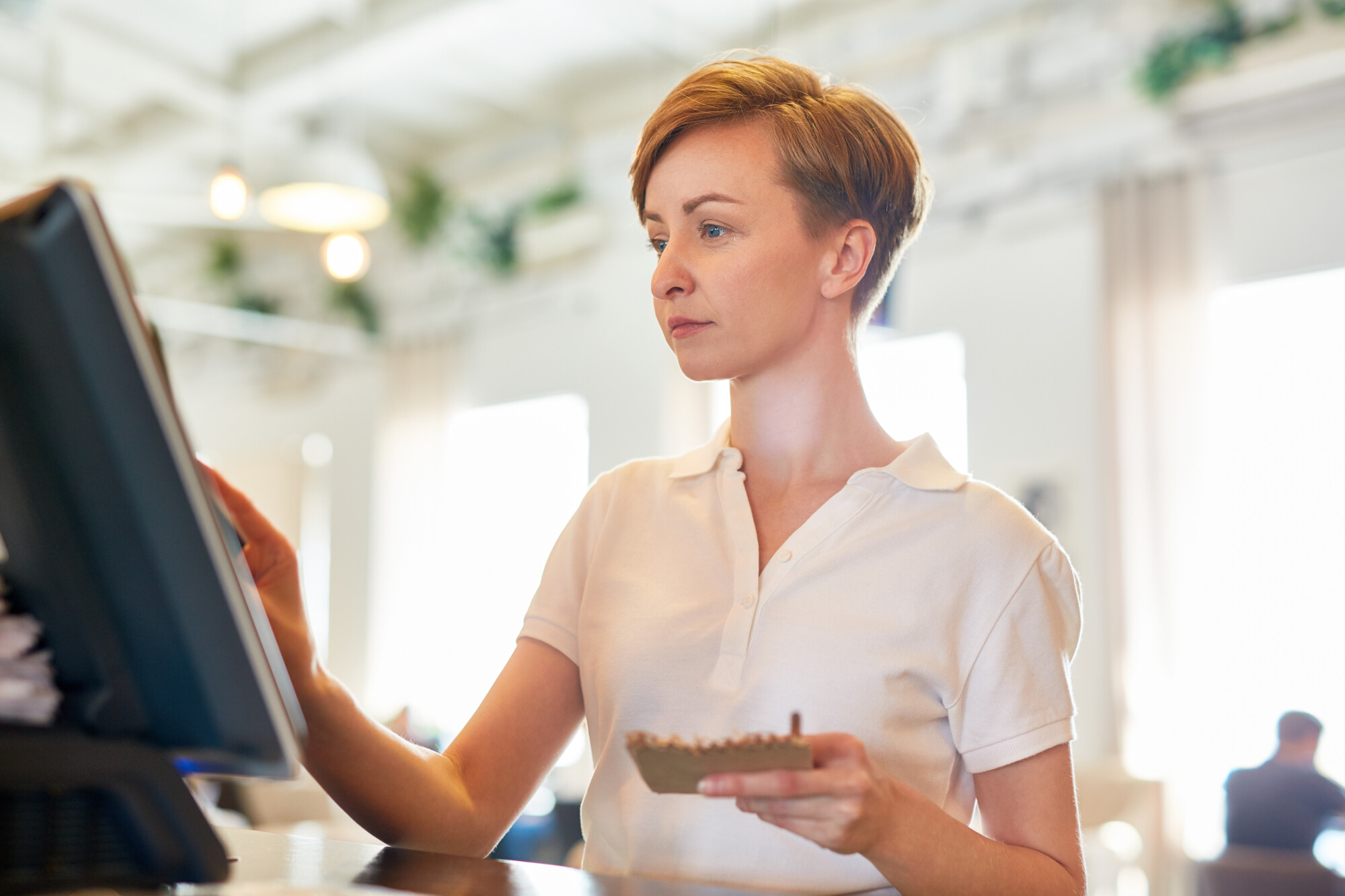 Employee using an electronic point-of-sale system in a hospitality business